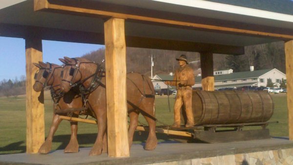 Wooden Sculptures of work horses pulling sap sled and farmer