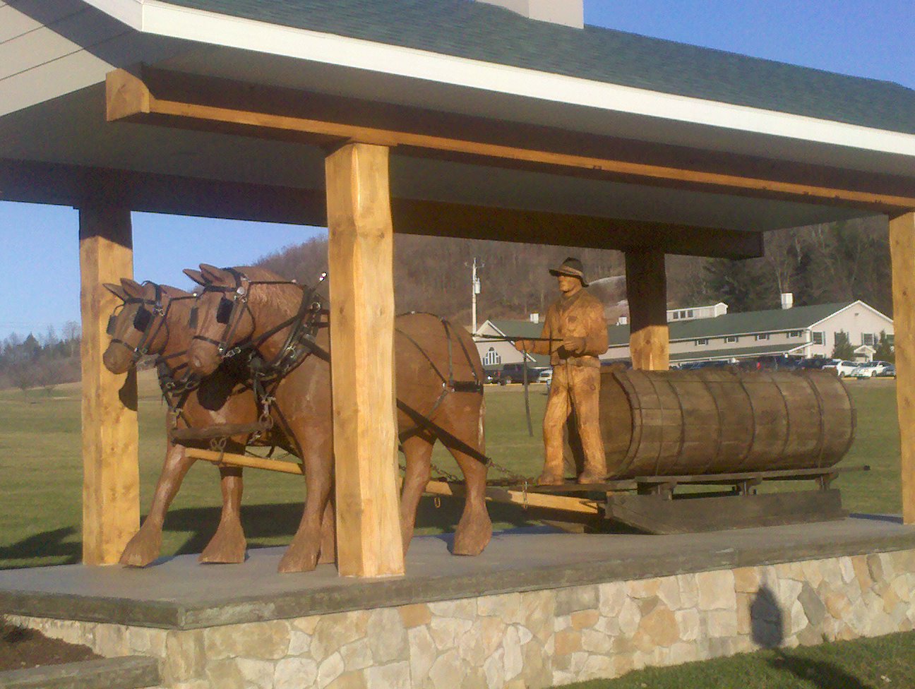 Wooden Sculptures of work horses pulling sap sled and farmer